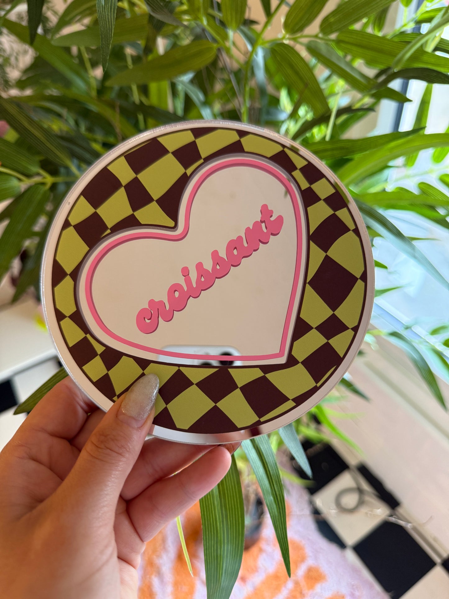A hand holding a heart-shaped object with a checkered pattern and the word "Sapphires" written on it.