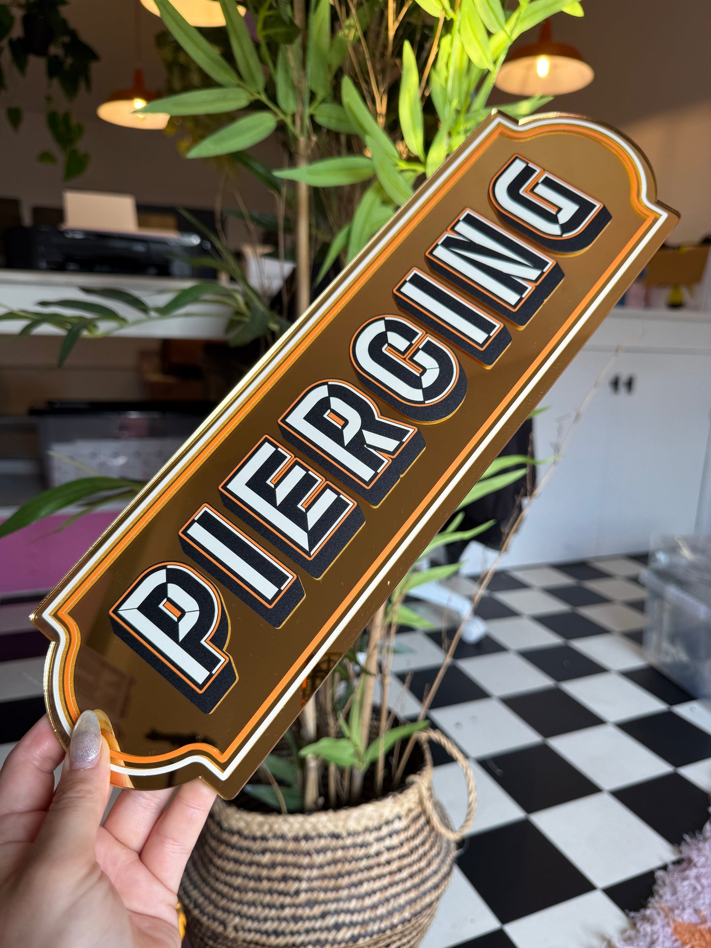 A person is holding a sign with the word "PIC" on it, which is a stylized representation of the word "PIC" in a decorative font.