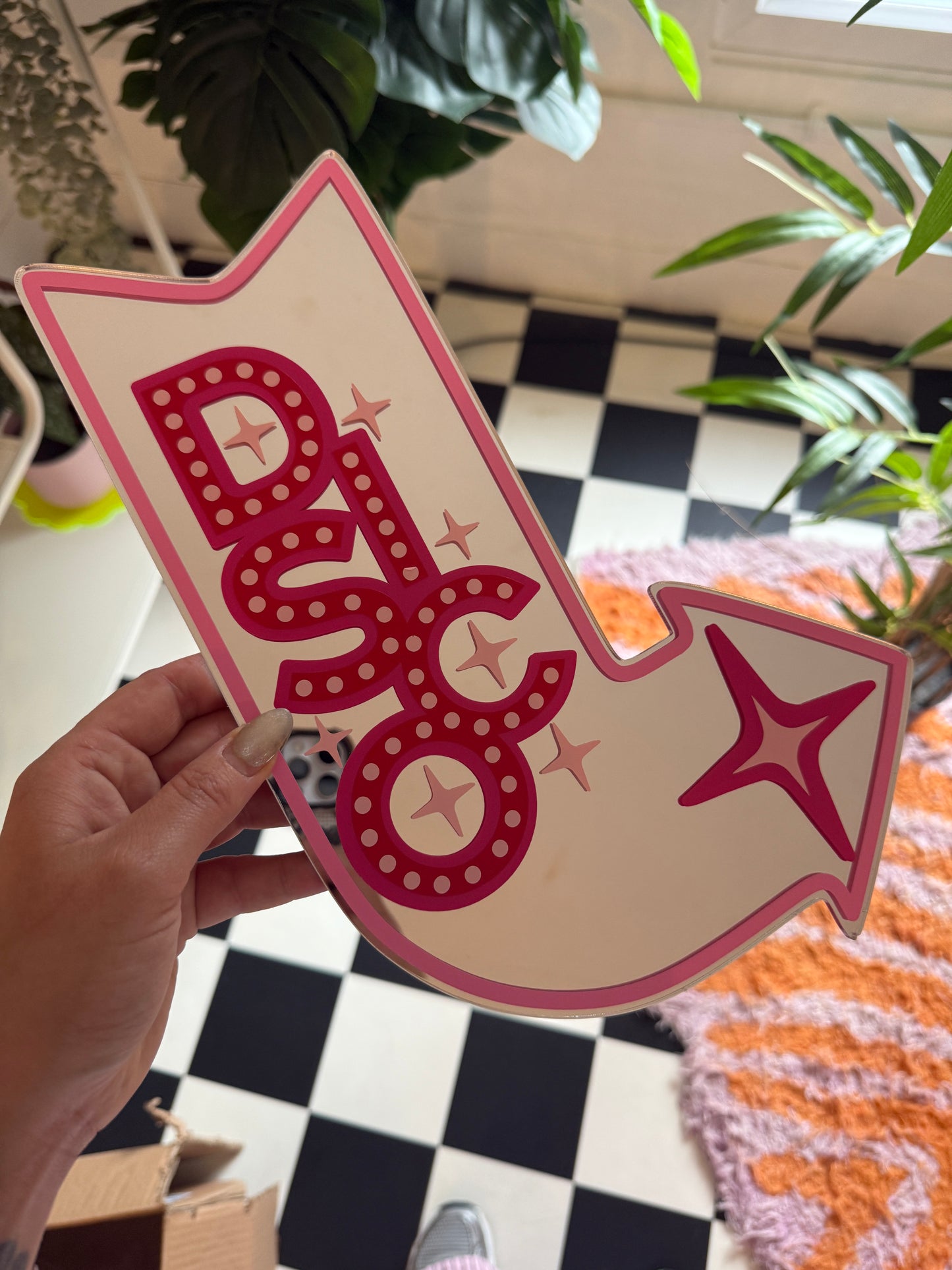 A hand is holding a pink and white sign with a star and the word "DUO" written on it.