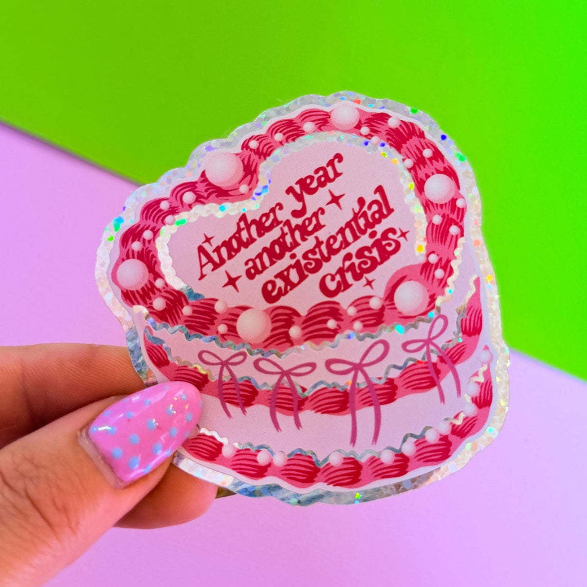 Sticker with text held by a hand against a colorful background