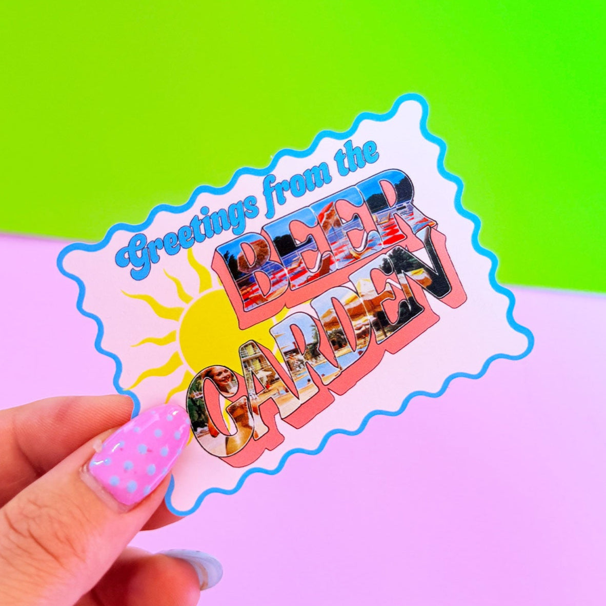 Sticker with 'Greetings from the Sun' design held by a hand against a colorful background