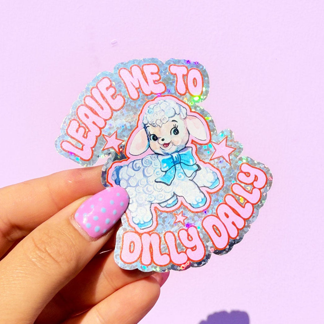 Sticker with a cartoon character and text held by a hand against a purple background