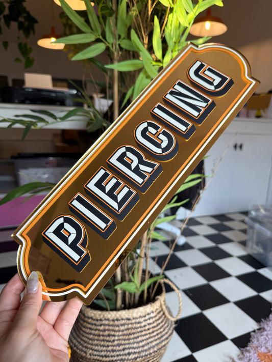 A person is holding a sign with the word "PIC" on it, which is a stylized representation of the word "PIC" in a decorative font.