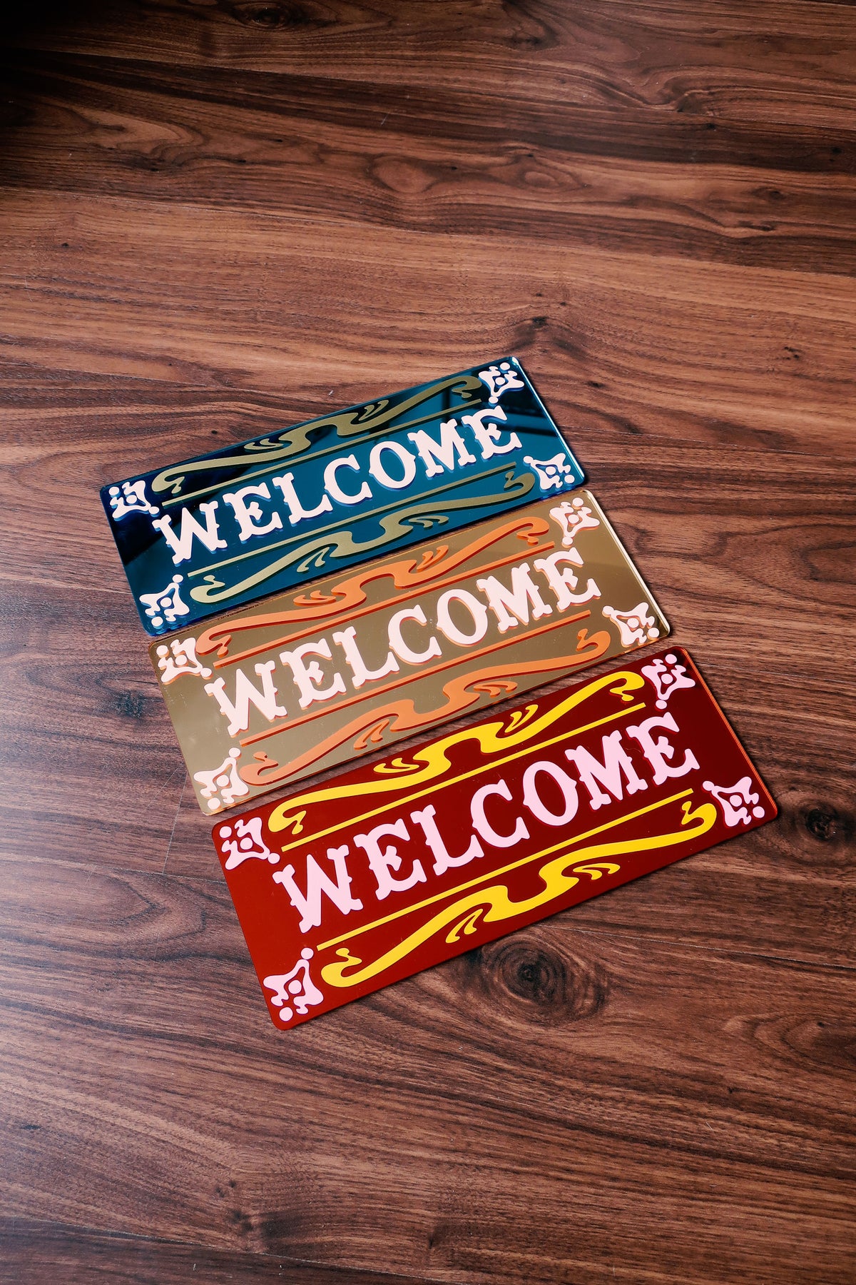 a wooden floor with three colorful welcome signs placed on it.
