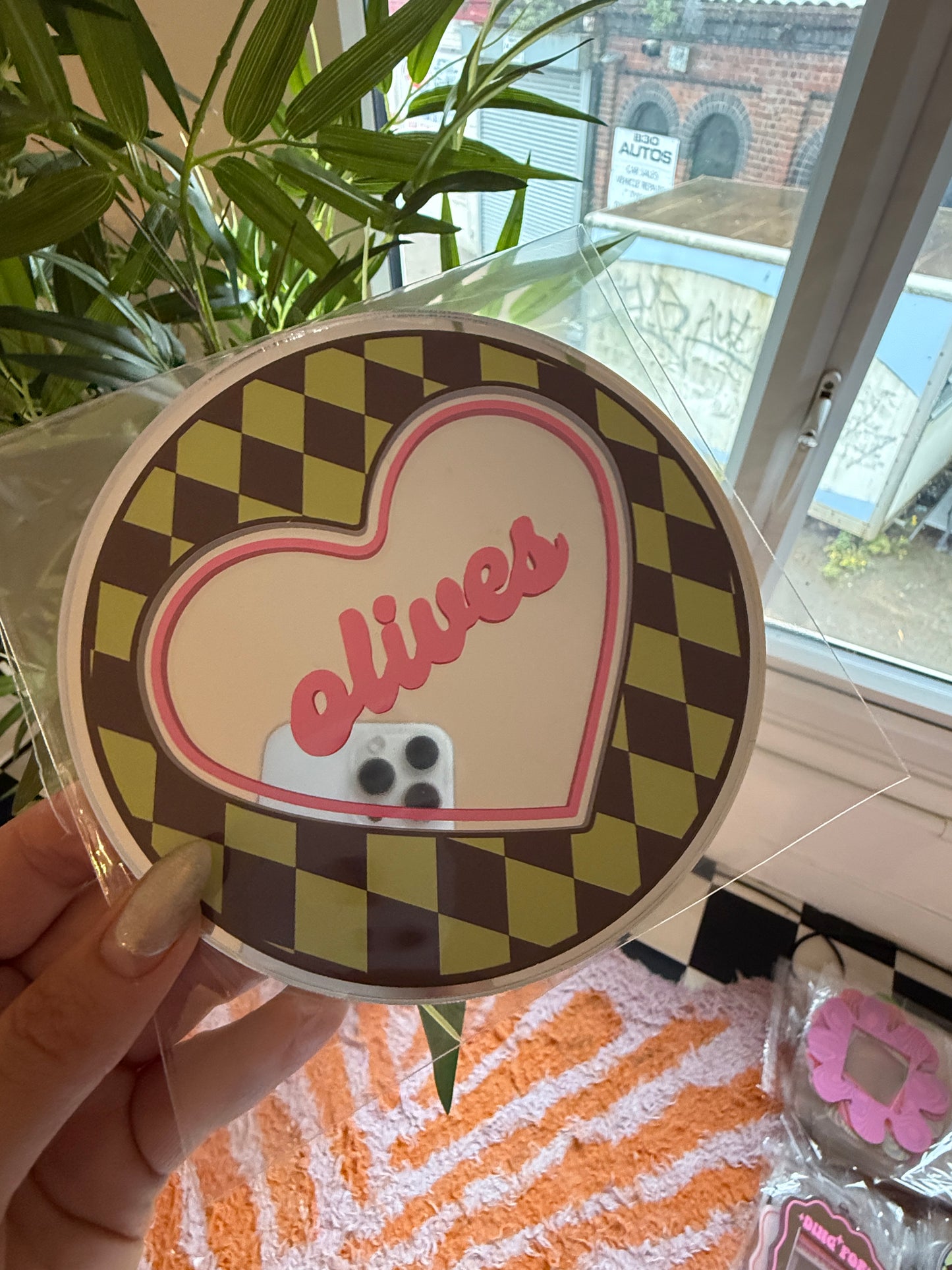 A person's hand holding a heart-shaped object with a checkered pattern and the word "Pomodoro" written on it.