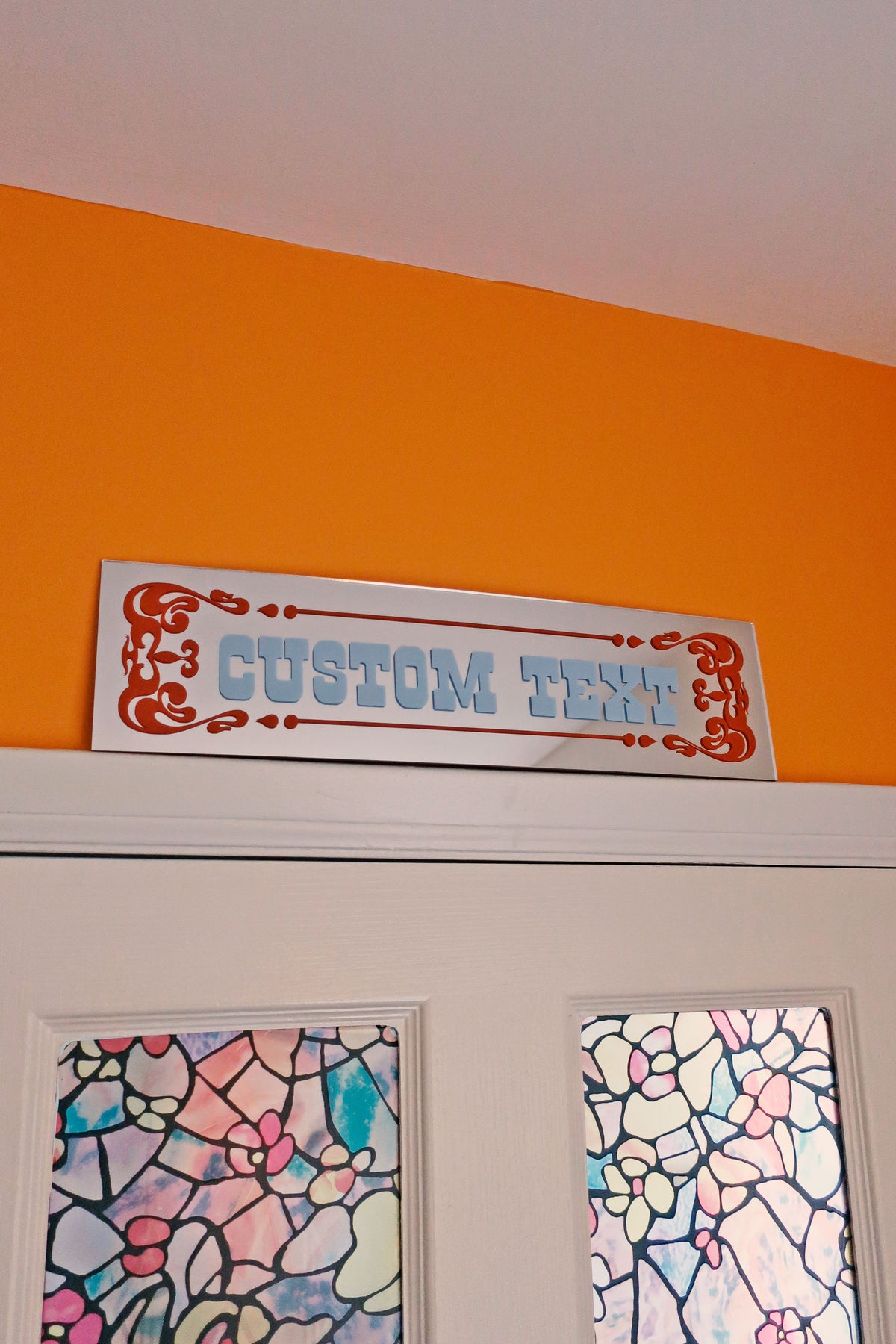 a sign that reads "CUSTOM TENT" above a door with two stained glass windows.
