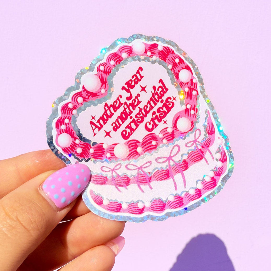 Hand holding a decorative sticker with text on a purple background