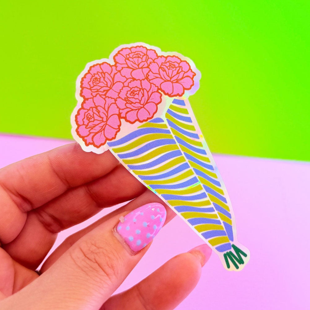 Hand holding a colorful ice cream cone sticker against a green and pink gradient background