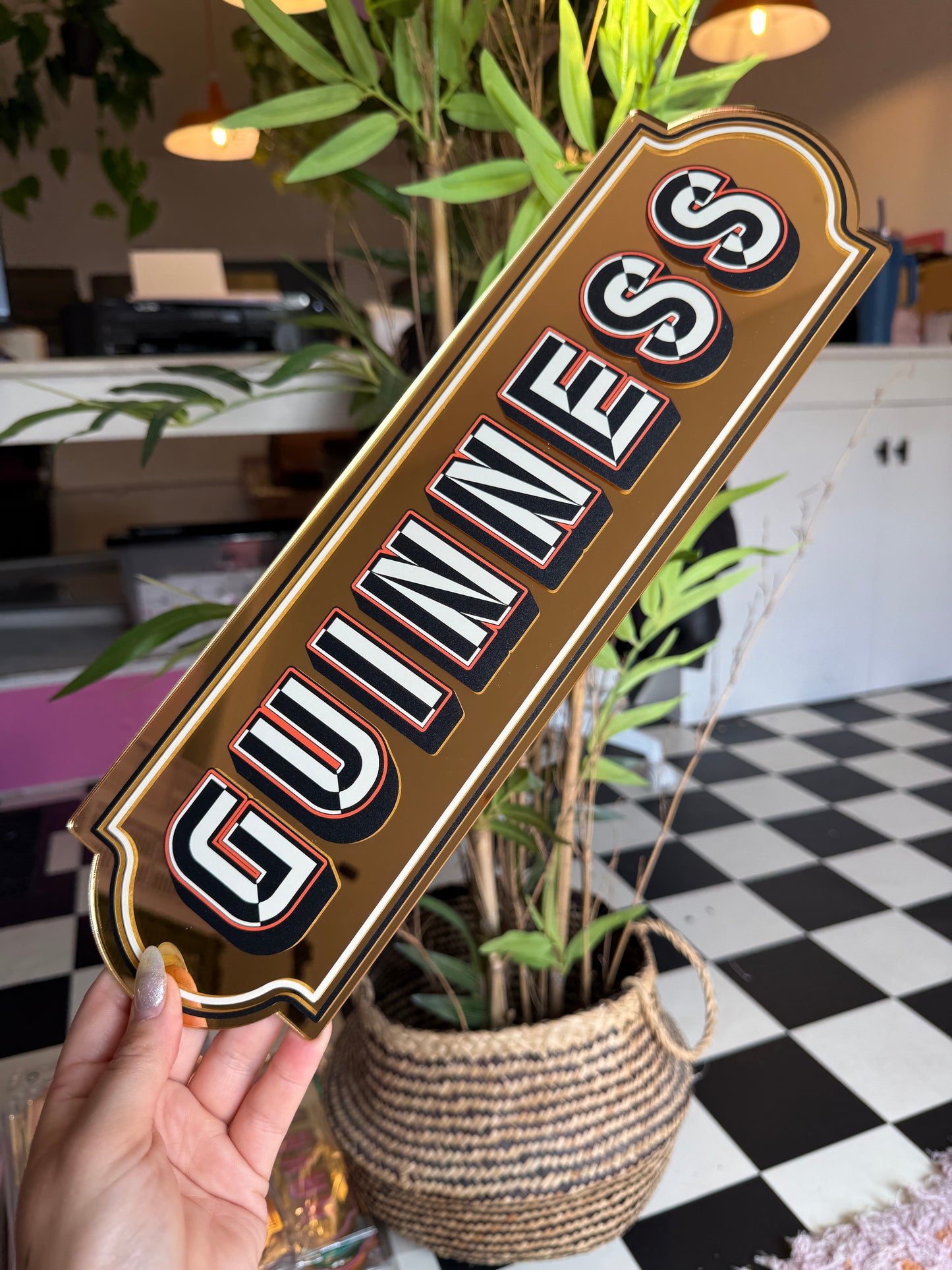 A hand holding a sign with the word "GUINNESS" written on it.