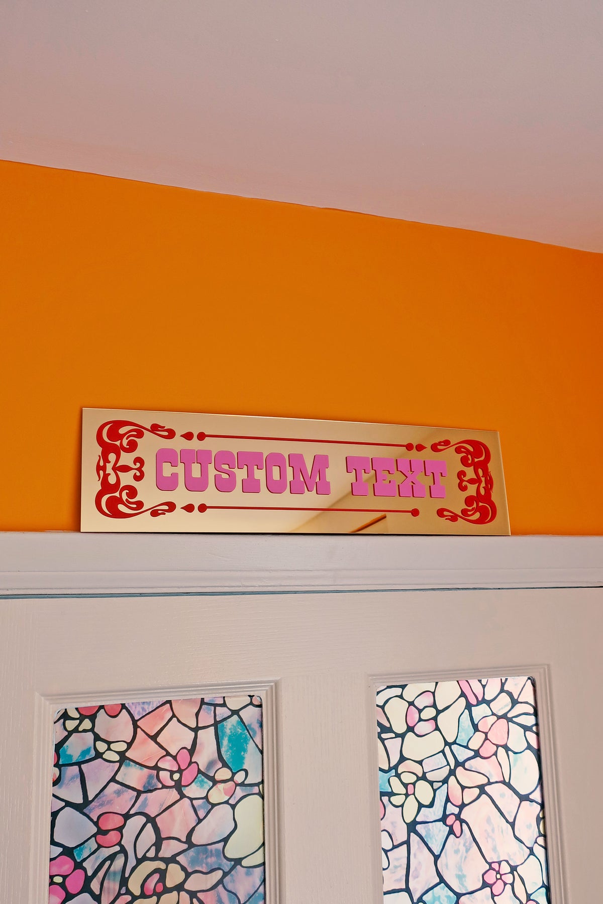 a sign that reads "CUSTOM TENT" above a door, with a colorful stained glass window below it.