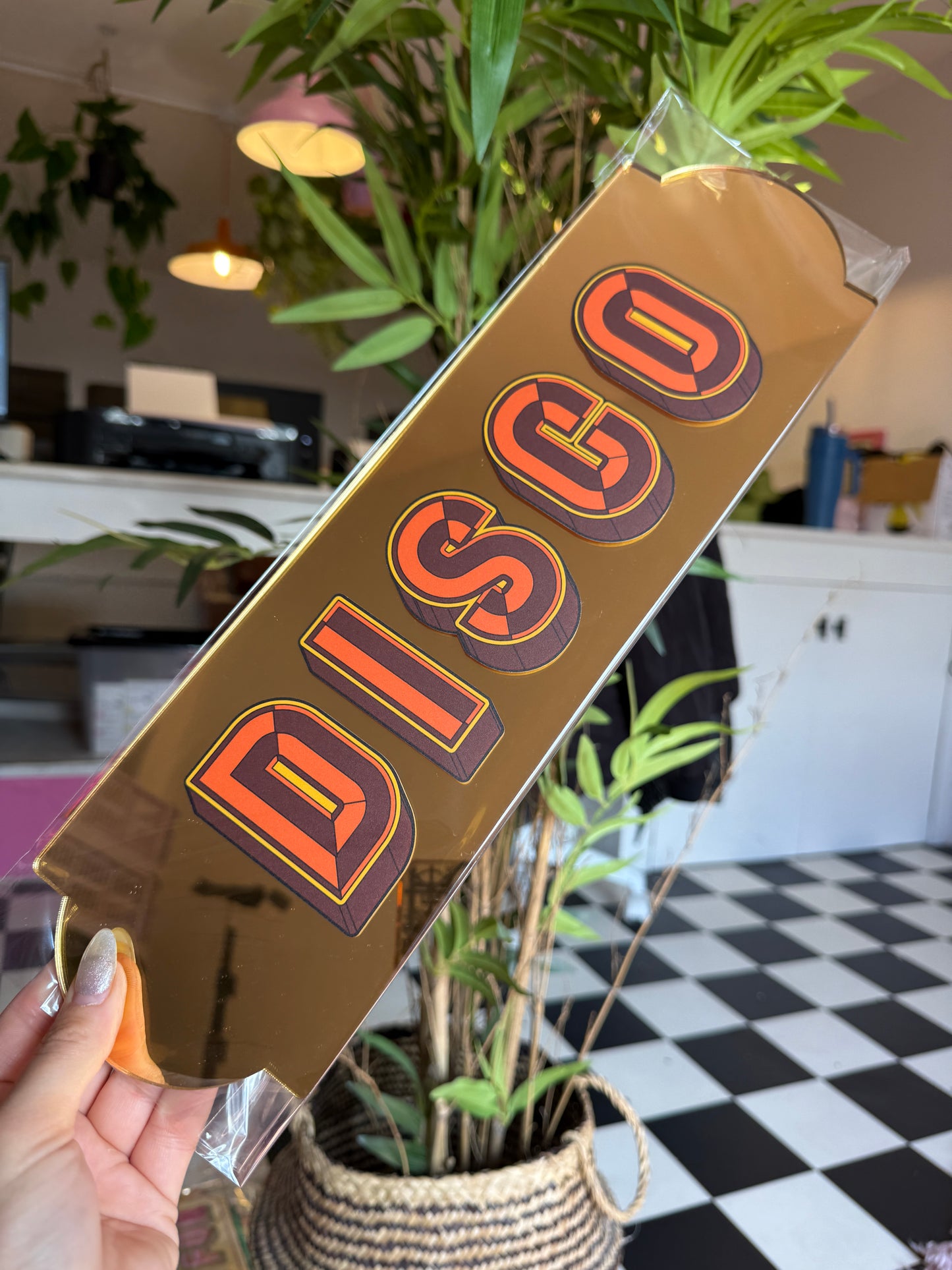 A hand holding a rectangular sign with the word "DIGO" written on it.