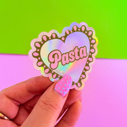 Heart-shaped holographic sticker with 'Pasta' text held by a hand against a colorful background